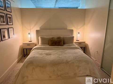 A bedroom with a large bed and two nightstands with lamps.