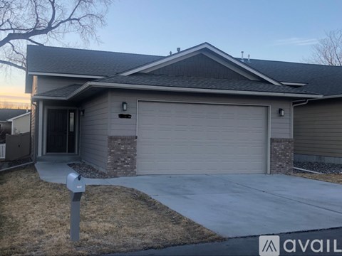 A house with a grey garage door and a mailbox in front.