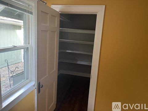 A white door is open to a room with empty shelves.