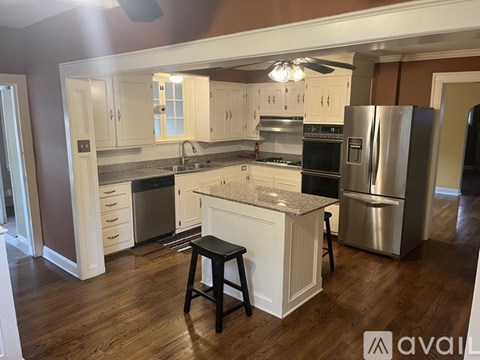 A kitchen with white cabinets and a granite countertop.