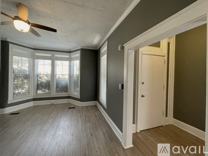 A room with a ceiling fan and sliding glass doors.
