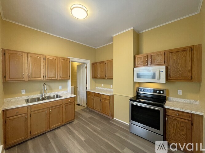 A kitchen with wooden cabinets and a stove top oven.