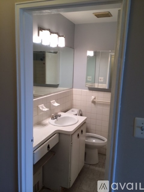 A bathroom with a sink, toilet, and mirror.