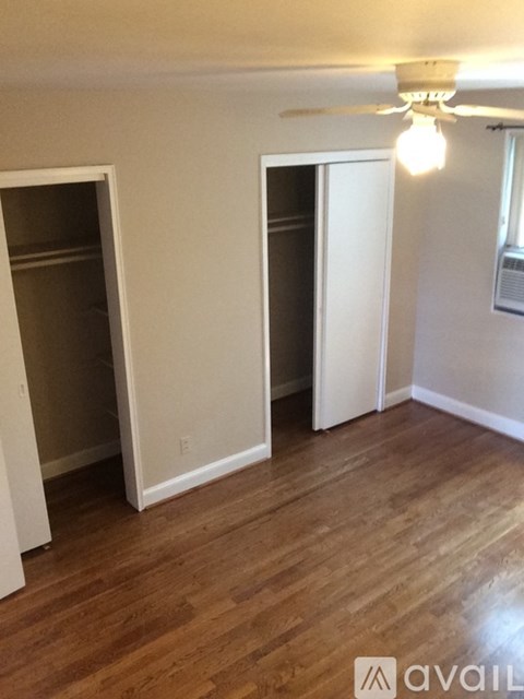 A room with wooden floors and two open doors.