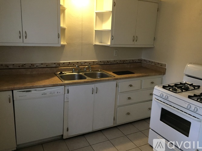 A kitchen with white cabinets and a white stove.