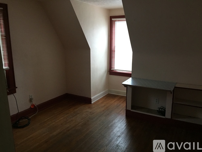 A room with a window and a wooden floor.