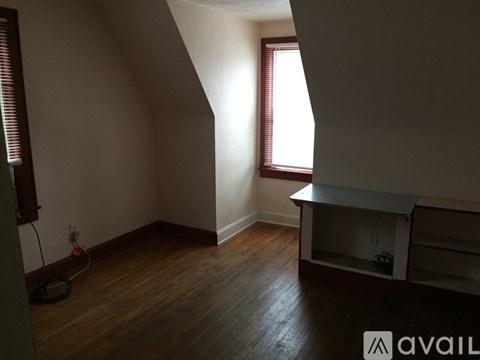 A room with a window and a wooden floor.