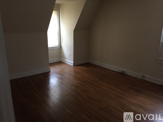A room with wooden flooring and a window.