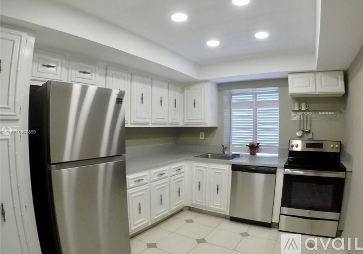 A kitchen with white cabinets and stainless steel appliances.