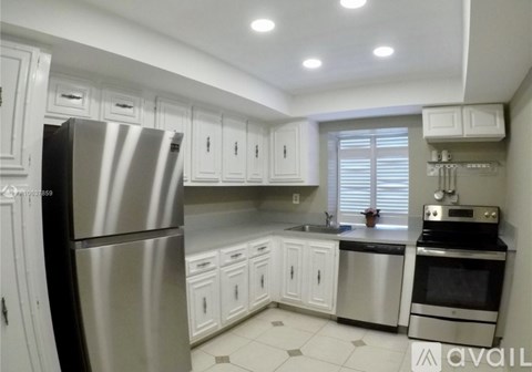 A kitchen with white cabinets and stainless steel appliances.