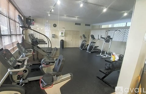 A gym with treadmills, exercise bikes, and other equipment.