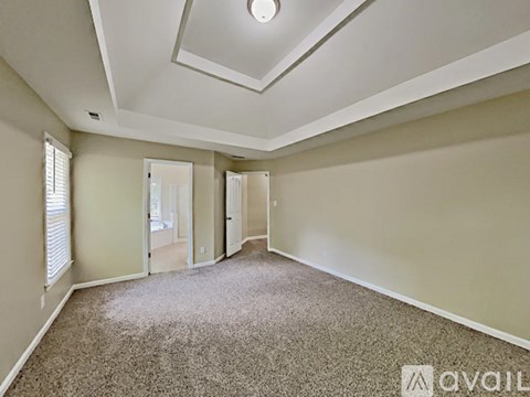 A spacious room with carpeted floor and a skylight.