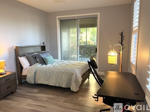 A bedroom with a bed, nightstand, and window.