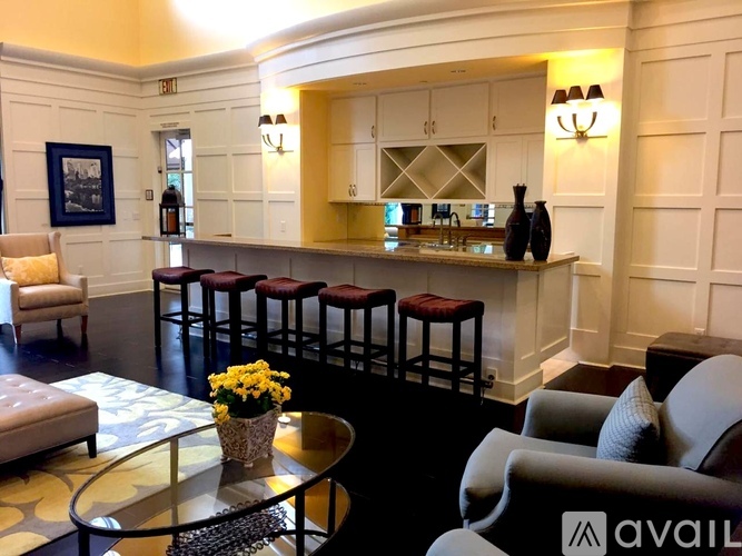 A living room with a bar area and a chair with a pillow on it.