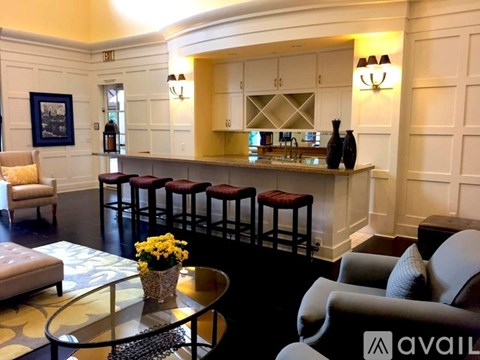 A living room with a bar area and a chair with a pillow on it.