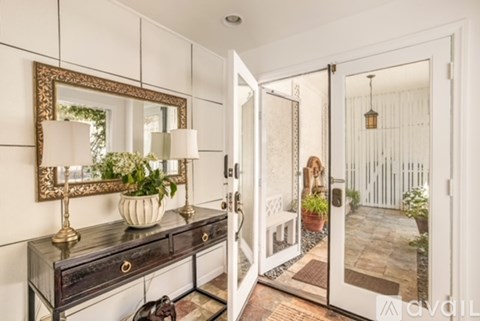 A white door is open to a patio.