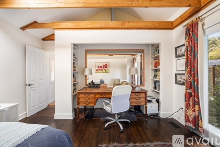 A bedroom with a desk and a chair in the middle of the room.