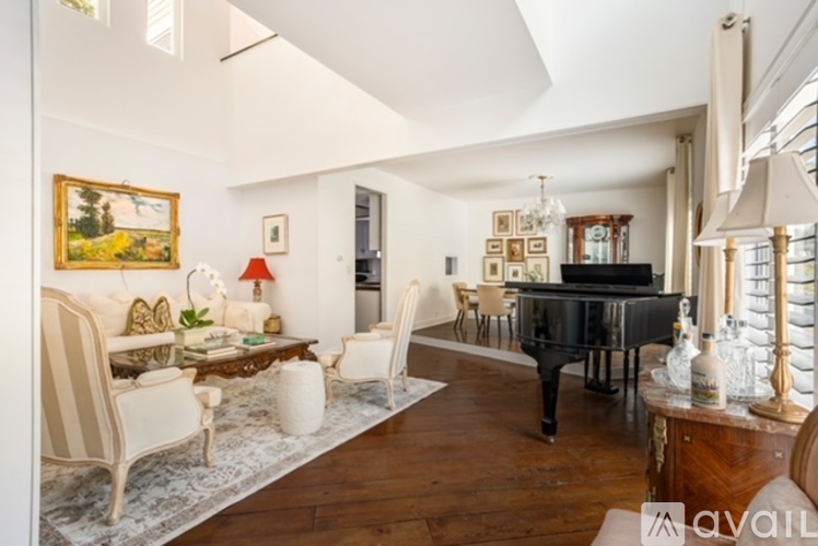 A living room with a piano and a painting on the wall.