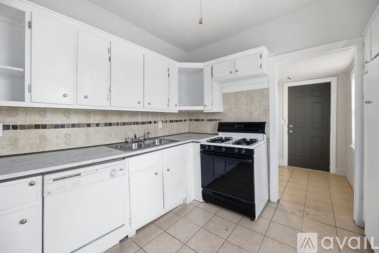 A kitchen with white cabinets and a black stove top oven.
