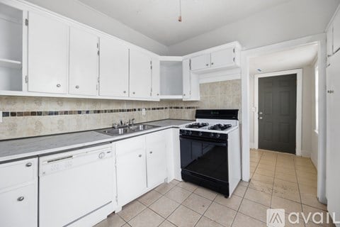 A kitchen with white cabinets and a black stove top oven.