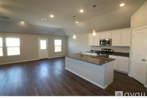 A kitchen with white cabinets and a wooden island.