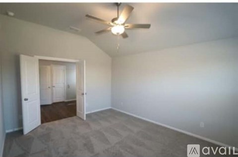 A room with a ceiling fan and carpeted floor.