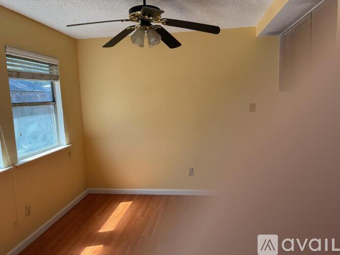 A room with a ceiling fan and a window.