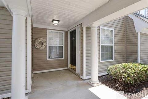 A house entrance with a door and a wreath on the wall.