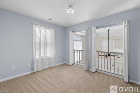 A spacious room with a white door leading to a balcony.
