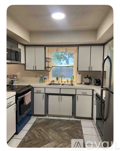 A kitchen with white cabinets and a black oven.