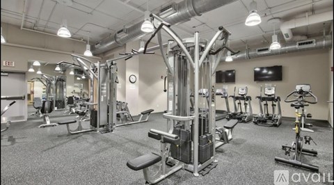 A gym with a variety of equipment including weights, machines, and cardio machines.