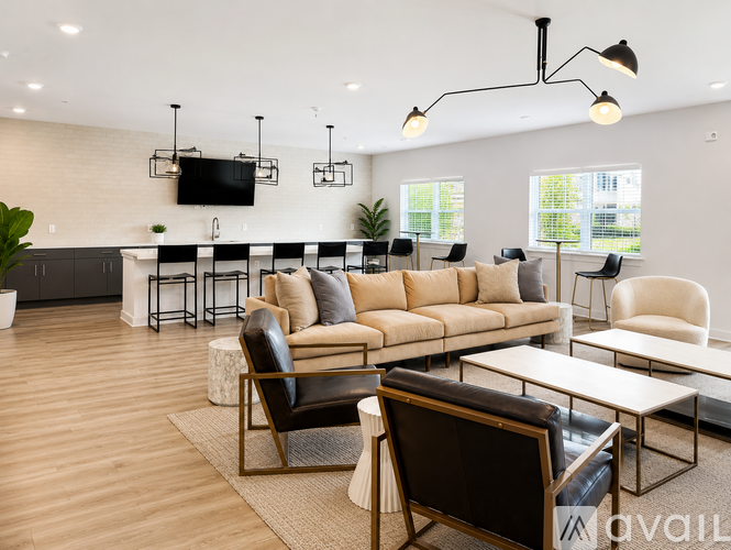 A modern living room with a large sofa, armchairs, and a coffee table.