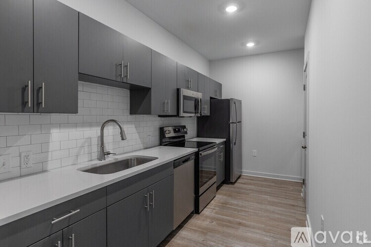 A kitchen with a sink, stove, and refrigerator.