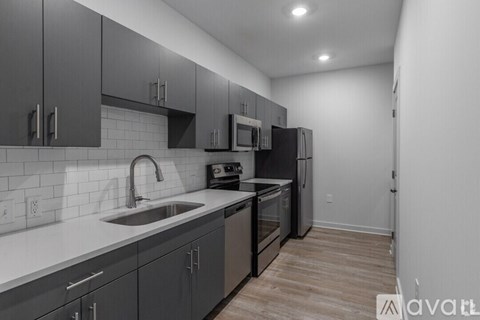A kitchen with a sink, stove, and refrigerator.