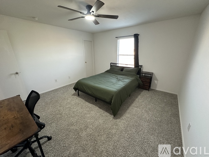 A bedroom with a bed, chair, and table.
