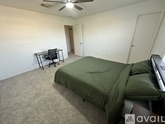 A bedroom with a bed, a chair, and a desk.