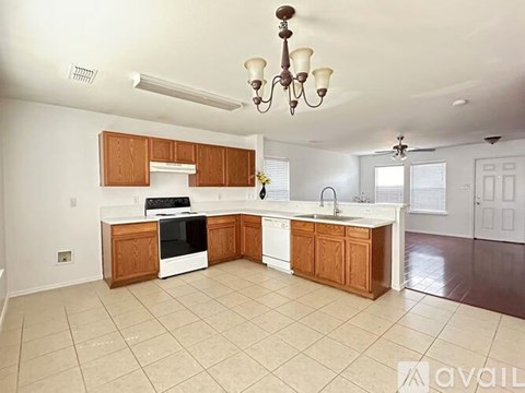 A kitchen with white appliances and wooden cabinets.