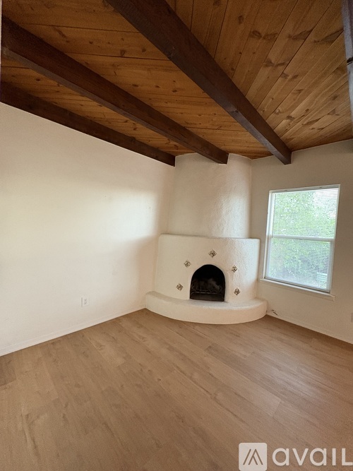 A room with a fireplace and wooden floors.