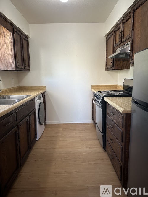 A kitchen with wooden cabinets and a white wall.