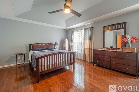 A bedroom with a bed, dresser, and mirror.