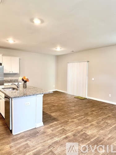 A kitchen with a granite countertop and a white dishwasher.