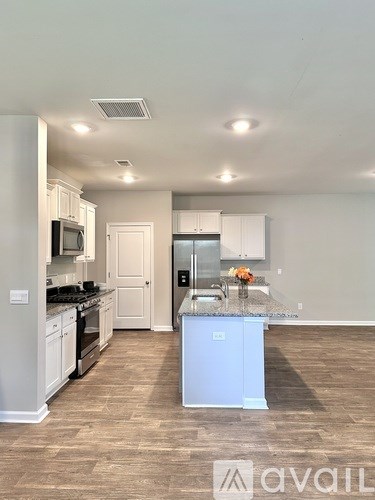 A kitchen with a white fridge, microwave, and oven.