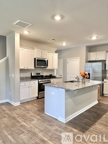 A kitchen with a white island and a microwave above it.