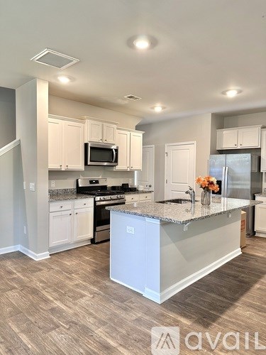A kitchen with a white island and a microwave above it.