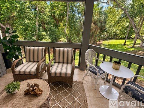 A patio with a table, chairs and a view of trees.