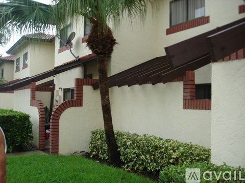 A palm tree in front of a building with a sign that says "available".