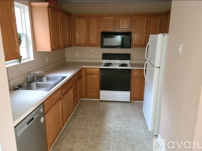 A kitchen with wooden cabinets and a white refrigerator.