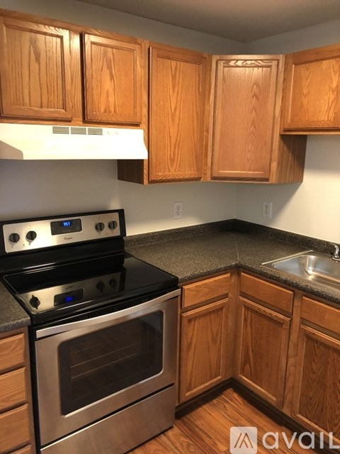 A kitchen with wooden cabinets and a black stove top oven.