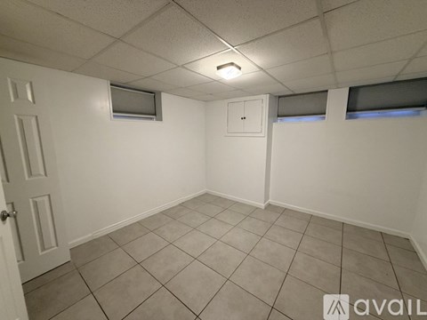 A room with white walls, a door, and a window with blinds.