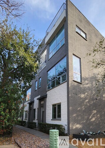 A modern building with a grey facade and large windows.